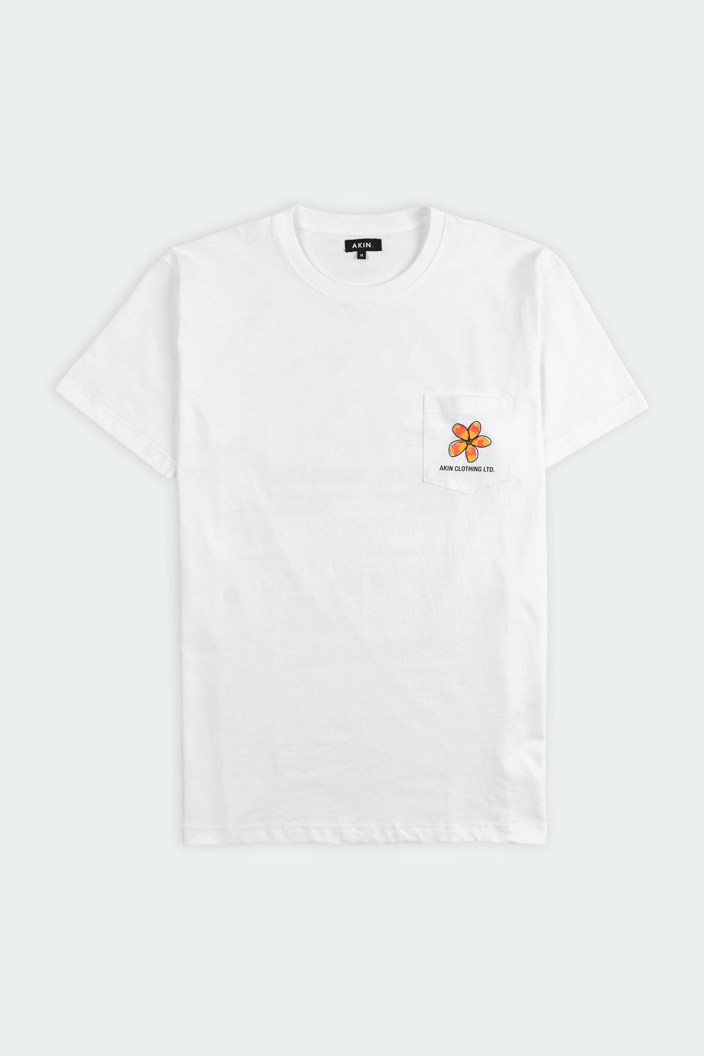 Ceylon Bloom white pocket t-shirt flat lay, small orange flower graphic and Akin Clothing Ltd text on chest