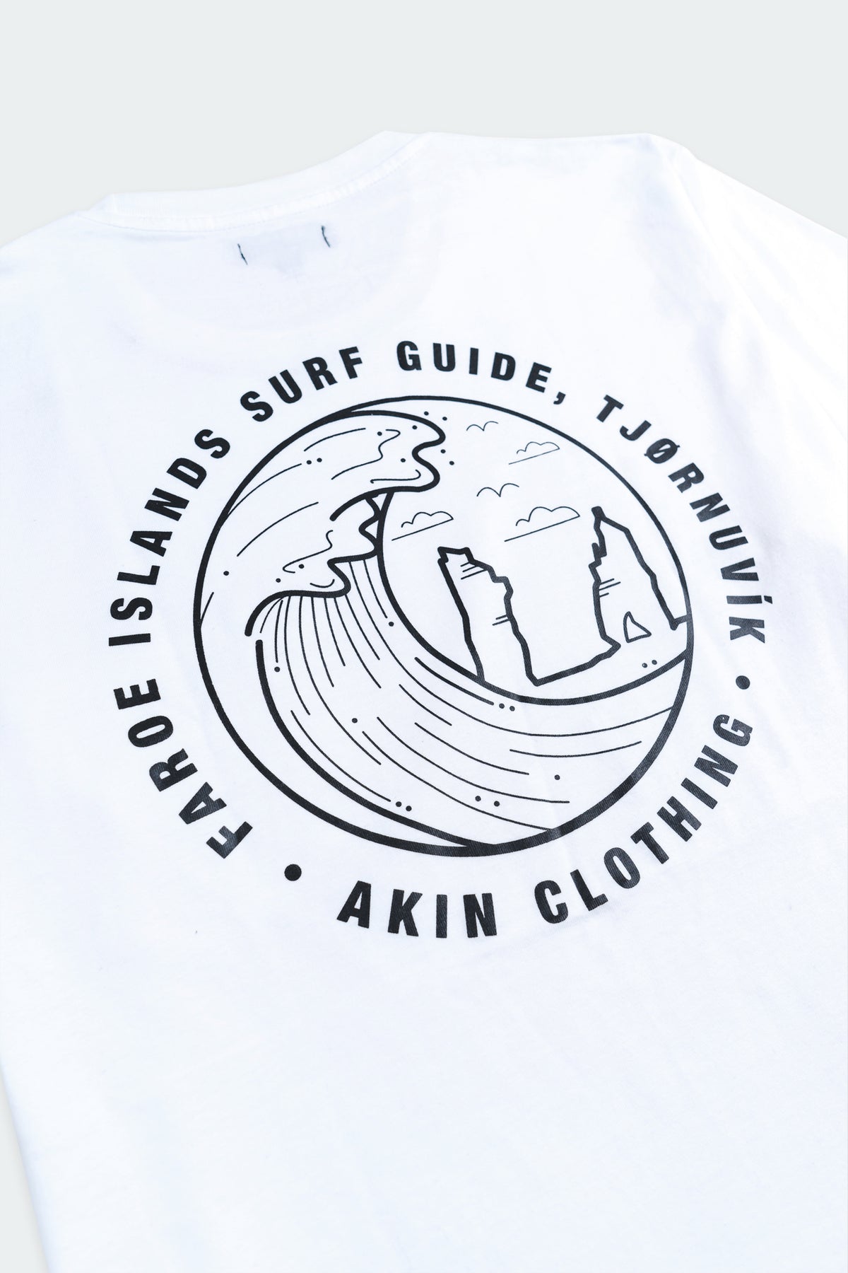 Back view of white Faroe Islands Surf Guide x Akin t-shirt with large circular wave graphic